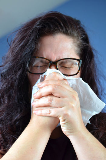 Woman blowing her nose with tissue