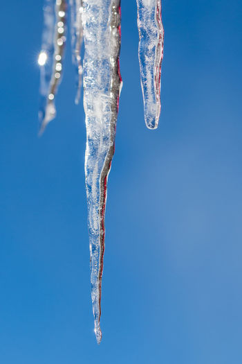 Close-up of ice crystals against blue sky