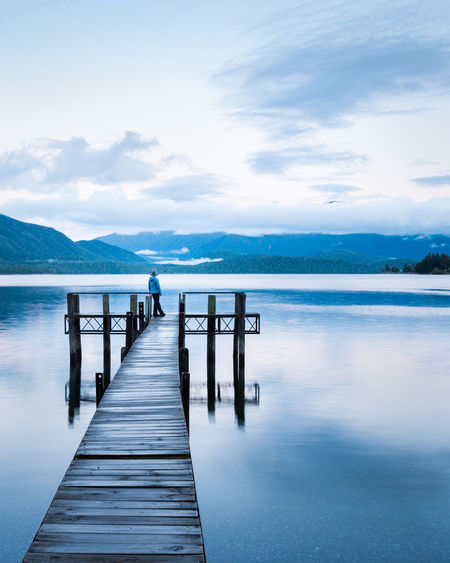 Wooden pier over lake against sky