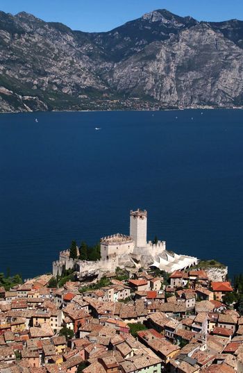 High angle view of townscape by lake garda  against sky