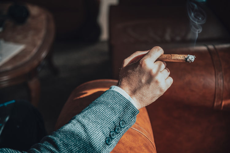 Close-up of hand holding cigarette