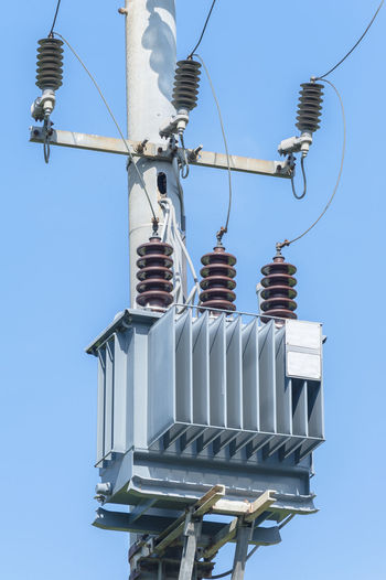 Low angle view of transformer against clear sky