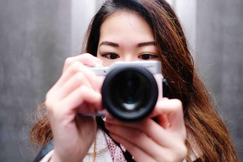 Portrait of woman holding camera
