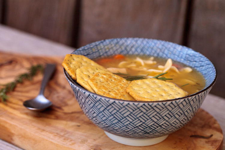 Close-up of soup with crackers on wooden table