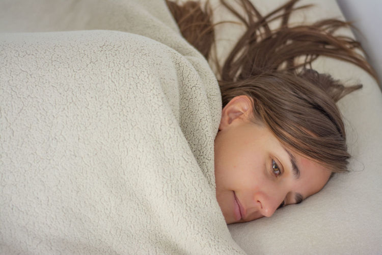Woman in bed covered up to the face