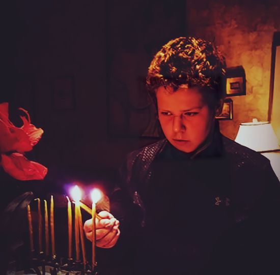 Portrait of man holding lit candles