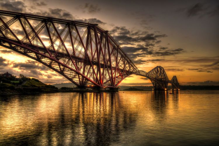 Firth of forth rail bridge over river against sky during sunset