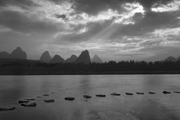 Scenic view of li river against cloudy sky