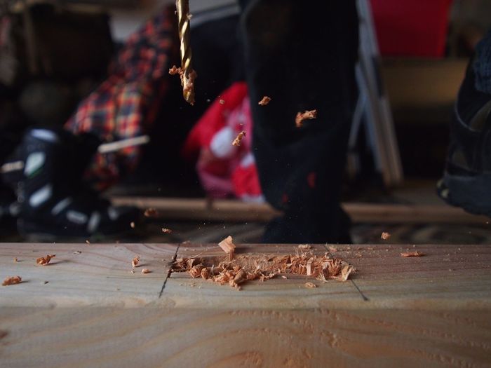Close-up of drill drilling wooden plank