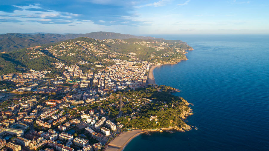 High angle view of cityscape by sea against sky
