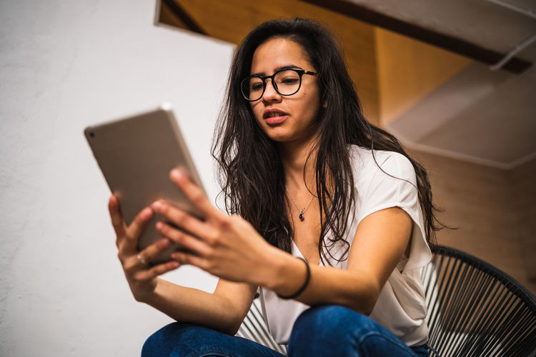 Low angle view of woman using digital tablet