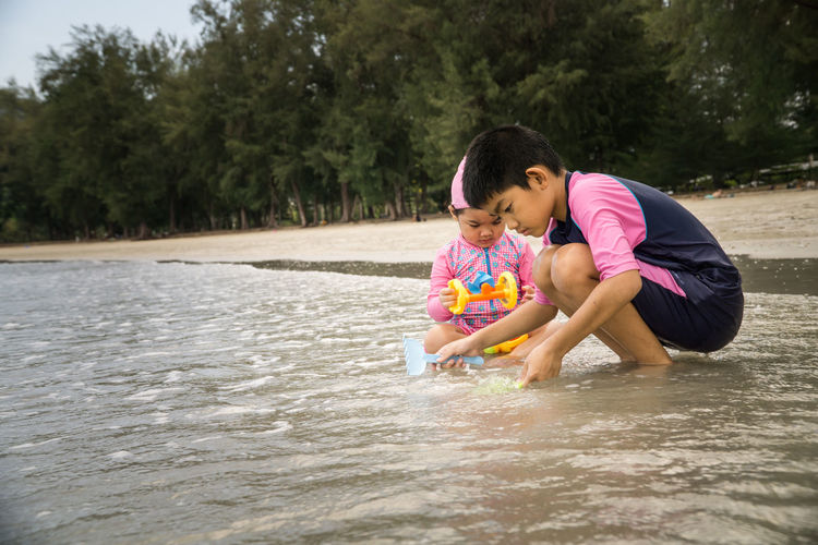 Side view of girl playing with toy in water