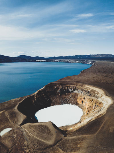 High angle view of volcanic crater by sea