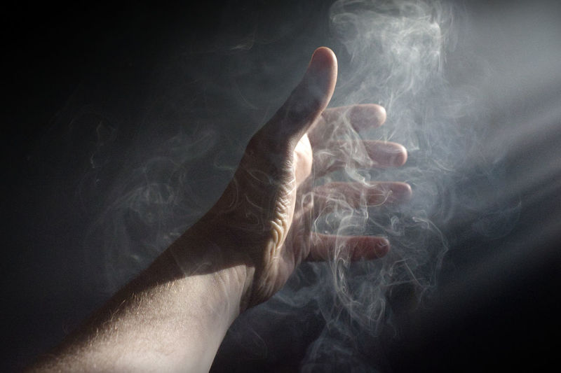 Close-up of human hand in smoke