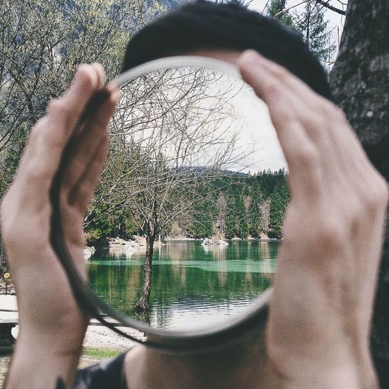 Close-up of man covering face with mirror