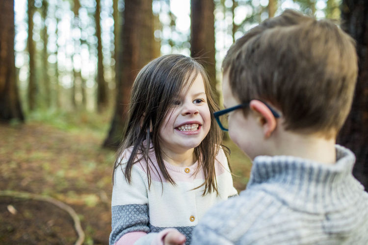 Playful boy and girl enjoying time outdoors in forest.