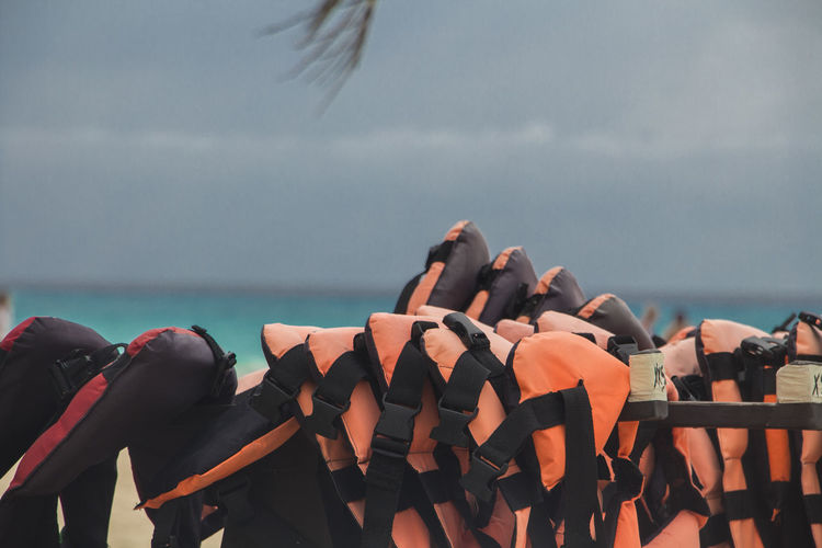 Close-up of life jackets hanging at beach