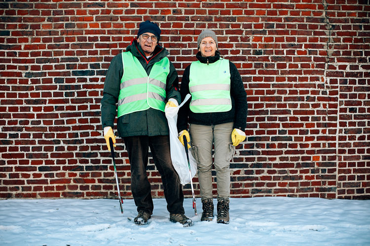 Portrait of a smiling elderly couple ready to collect garbage in the street. volunteer service