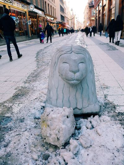 Statues on street in city during winter