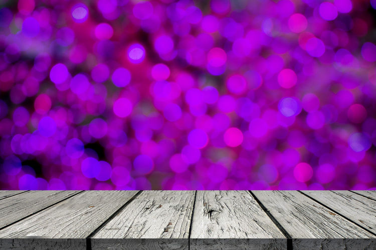 Defocused image of illuminated lights on wooden table