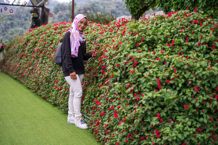 Full length of person standing by flowering plants