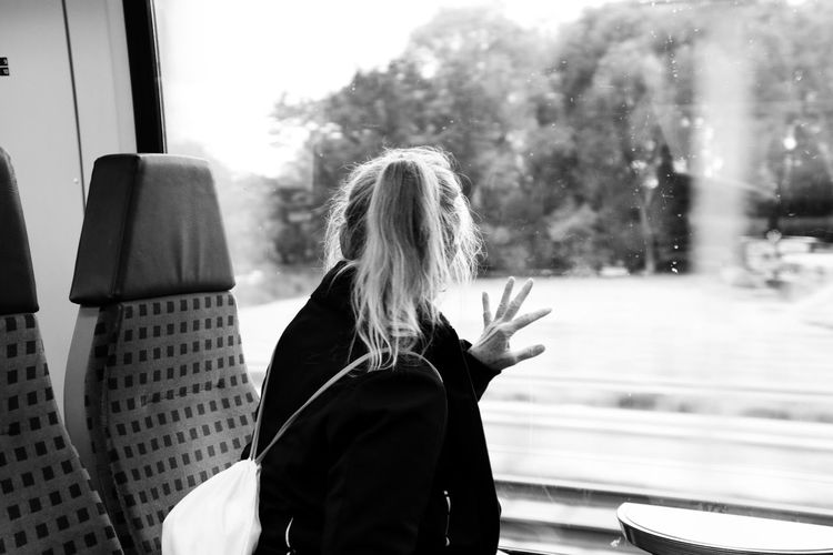 Rear view of woman looking through train window
