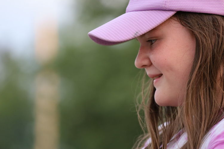 Close-up of smiling teenage girl wearing cap