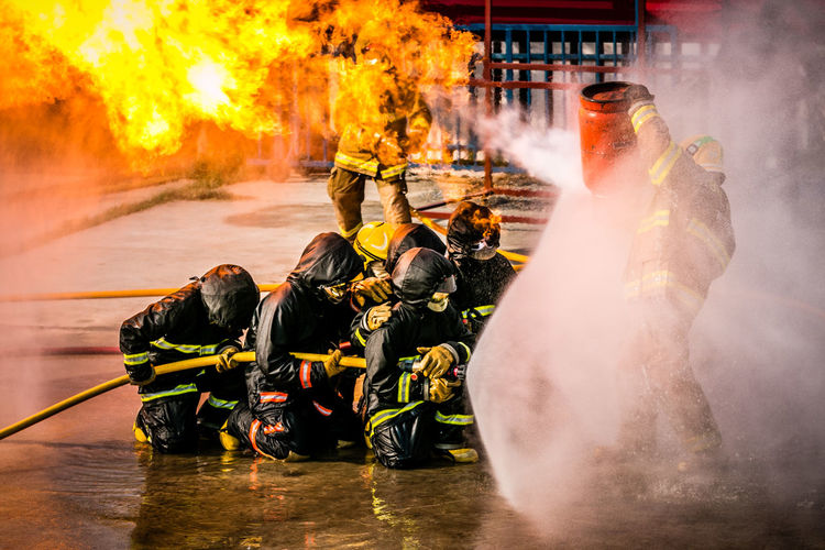 Firefighter spraying water on fire