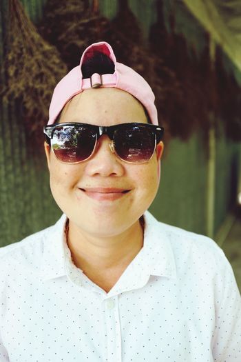 Portrait of smiling woman wearing sunglasses and cap