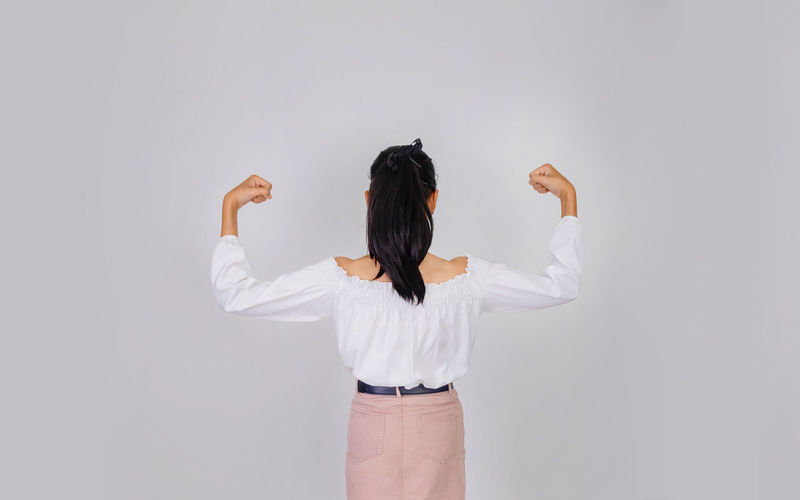 Rear view of woman standing against white background