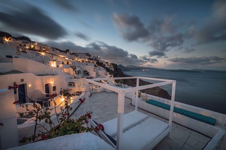Houses by sea against sky during sunset at santorini