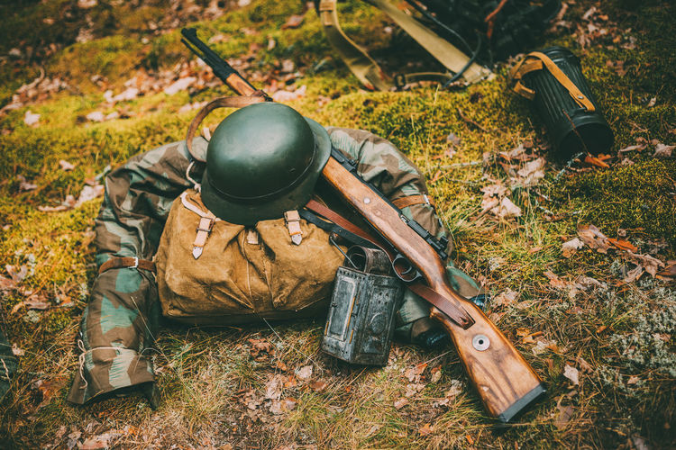Military uniform and weapon on land in forest