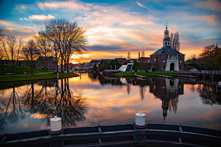 Reflection of building on river during sunset