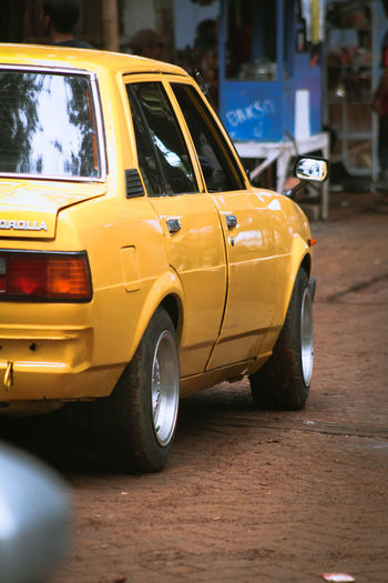 Close-up of yellow car on street