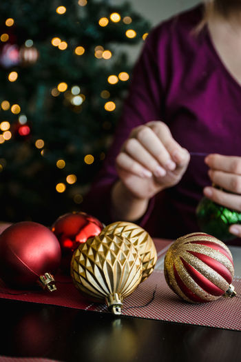 Cropped image of person decorating christmas baubles