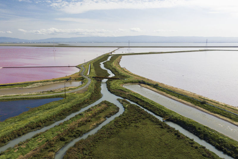 Multi colored water in ponds and stream in salt marsh in sf bay aerial