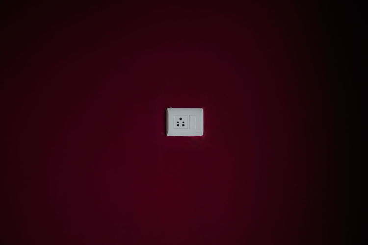 Electrical outlet on maroon wall