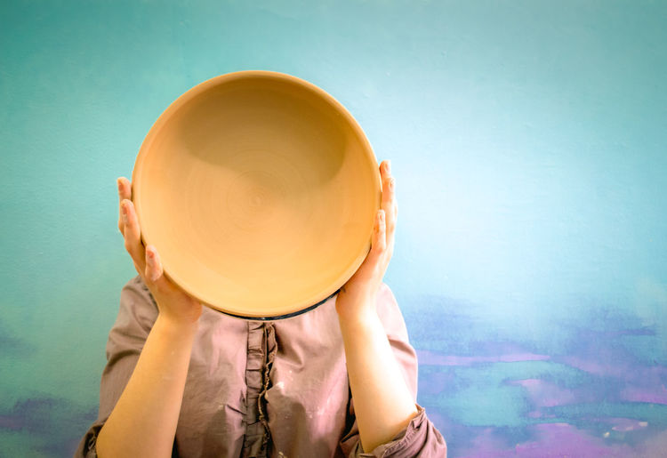 PORTRAIT OF WOMAN HOLDING HAT IN DRINKING GLASS