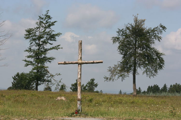 Cross on field against sky