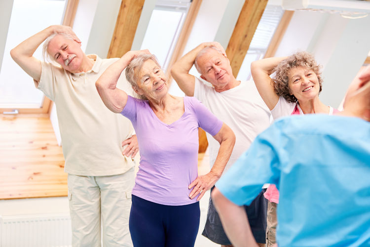 Senior people having exercise class in health club
