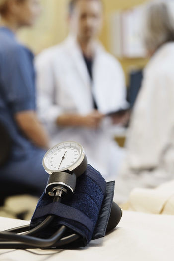 Blood pressure gauge with medical team discussing in background