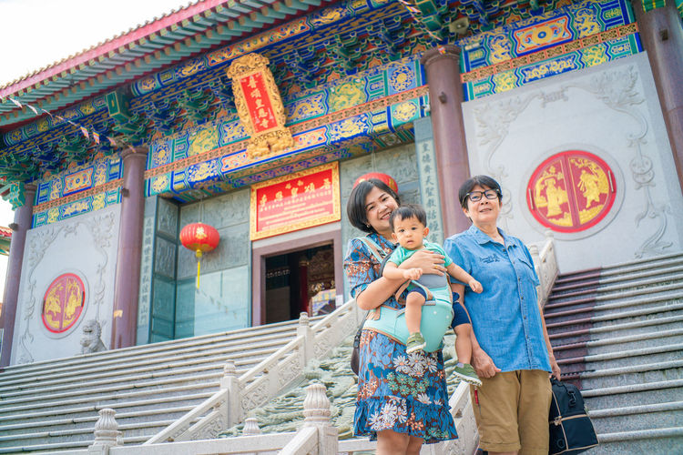 Portrait of family standing on staircase of temple
