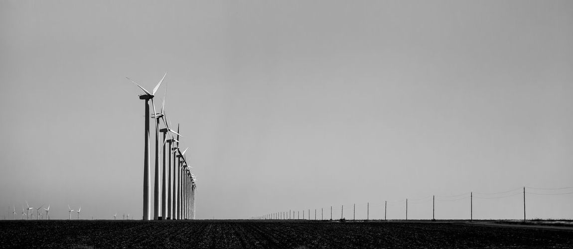 Low angle view of windmill on field against clear sky