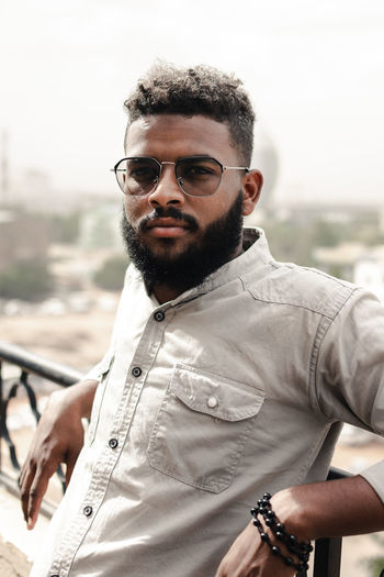 Portrait of young bearded man wearing sunglasses and grey shirt