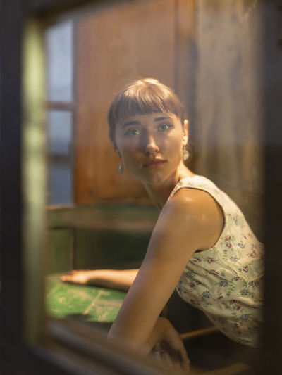 Portrait of woman against window