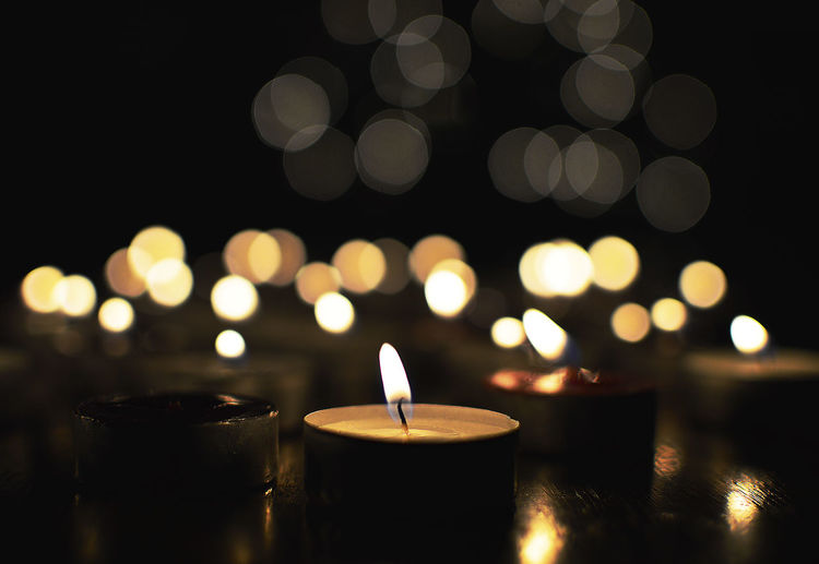 Close-up of lit tea light candles at night