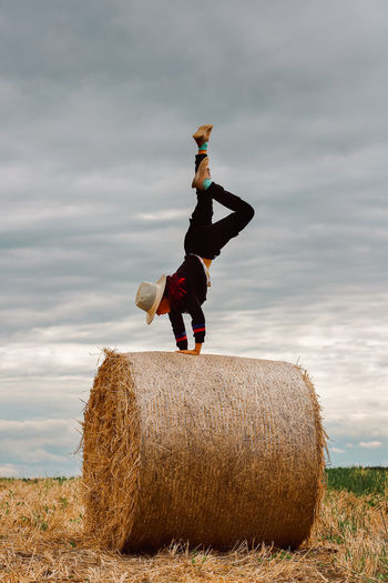A child on a haystack does a handstand. carefree childhood in the country, summer mood