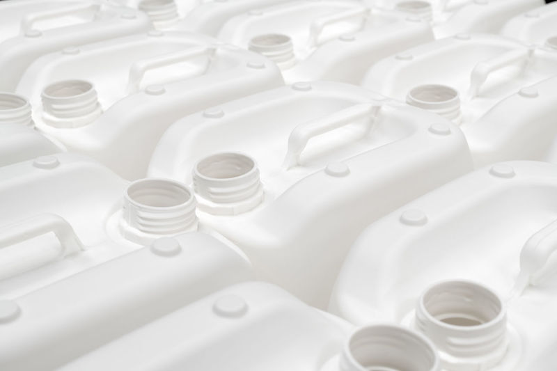 A group of white plastic jerry cans in a factory
