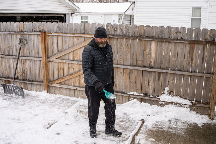 Man spreads rock salt to melt the ice and snow on your walkway