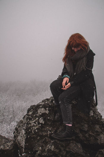 Woman in snow covered land during foggy weather